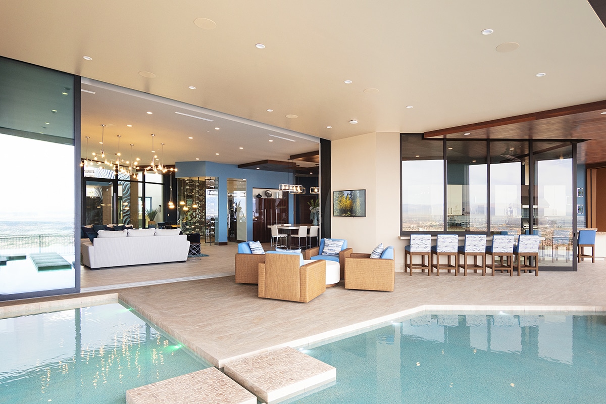A moving wall of glass opens to merge the interior great room with the spacious pool patio and lounge area.