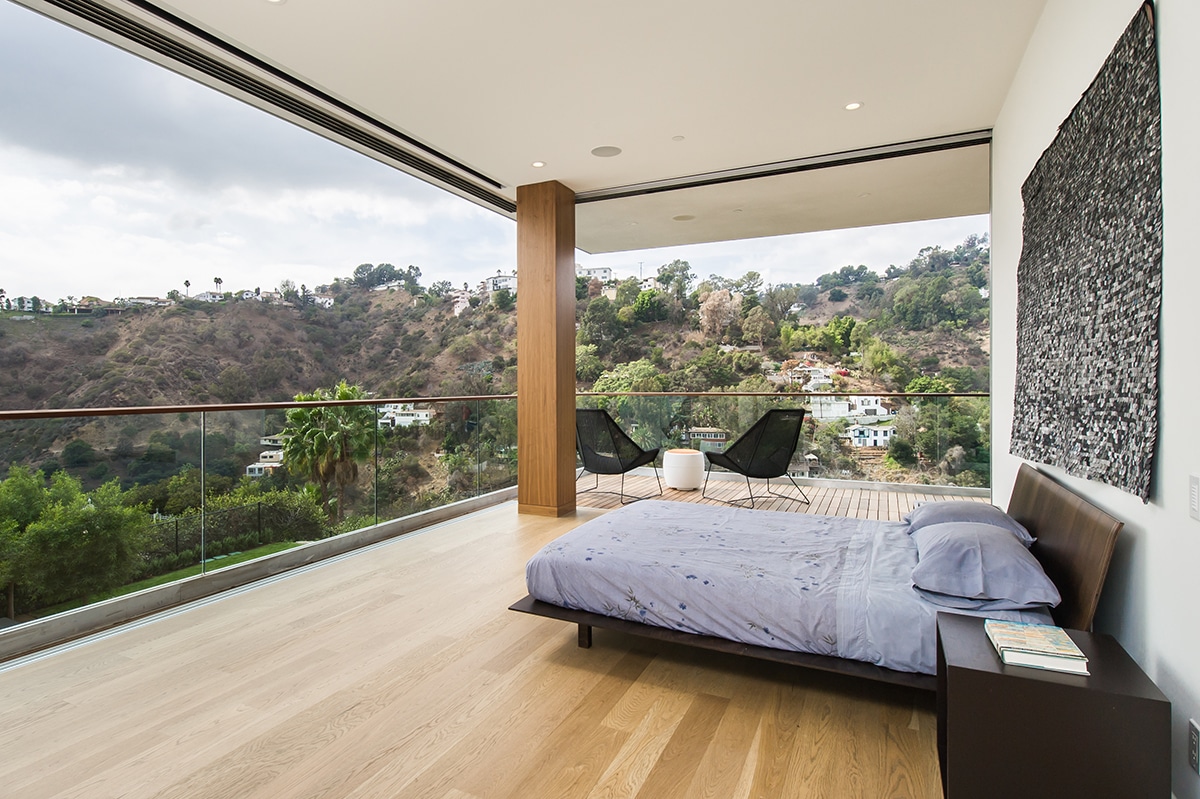 The multi-slide door in this bedroom disappears to connect the room to nature.