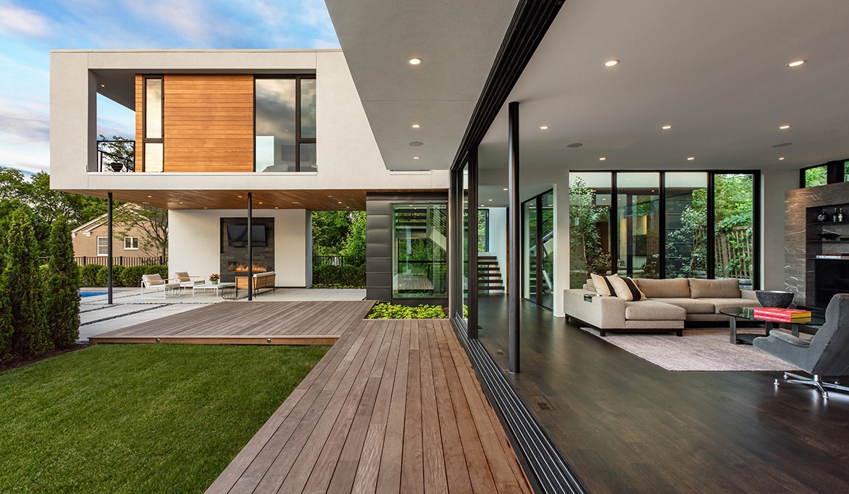 A view of the façade of the home with its floor-to-ceiling multi-slide doors completely open.