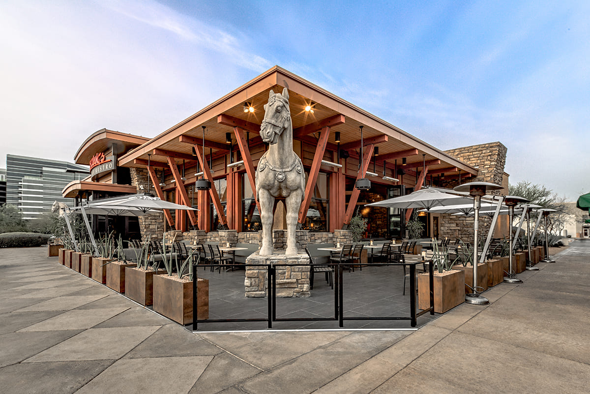The front view of a P.F. Chang’s with a giant horse statue.