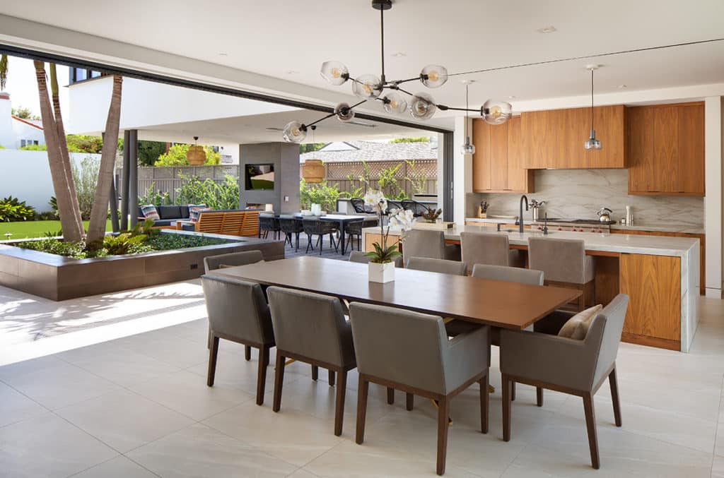 A wall-length Series 600 Multi-Slide Door glides open to completely merge the kitchen and dining areas with the backyard.