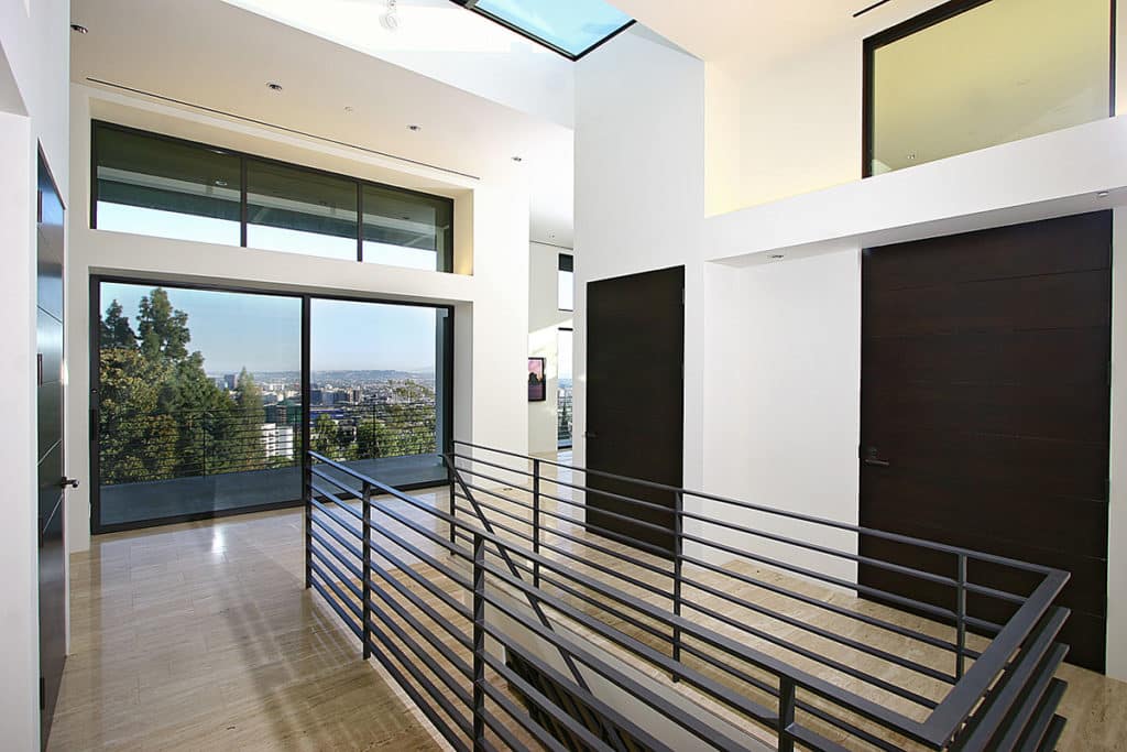 A massive sliding door situated in front of stairs opens to a balcony overlooking Los Angeles, letting in copious amounts of natural light and Southern California breezes.