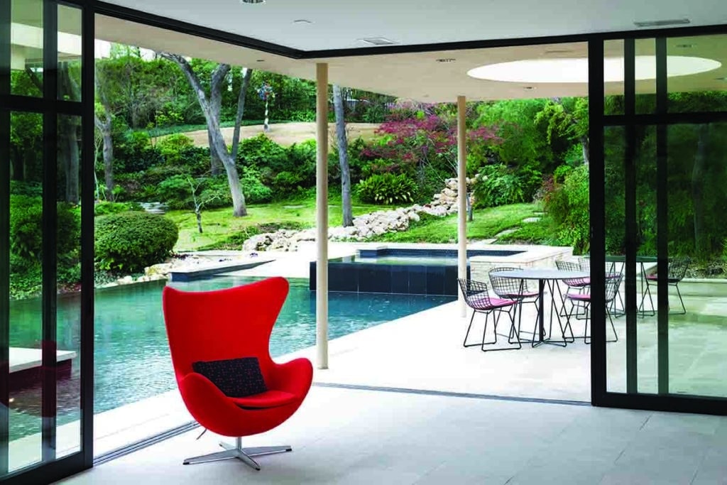 A 90-degree multi-slide door completely opens the interior of the home to the outdoor back patio and pool.