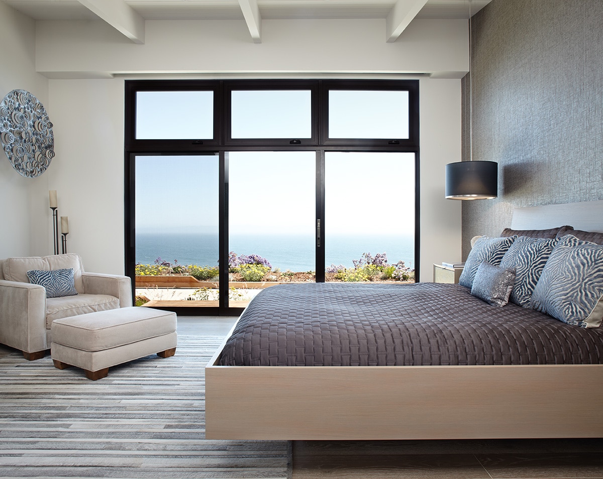 The master bedroom features a giant sliding glass door that opens up to the Pacific Ocean.