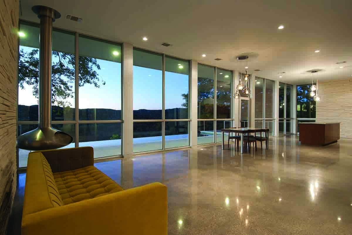 An incredible array of floor-to-ceiling Western Window Systems windows frames beautiful nighttime views of the Austin outskirts.