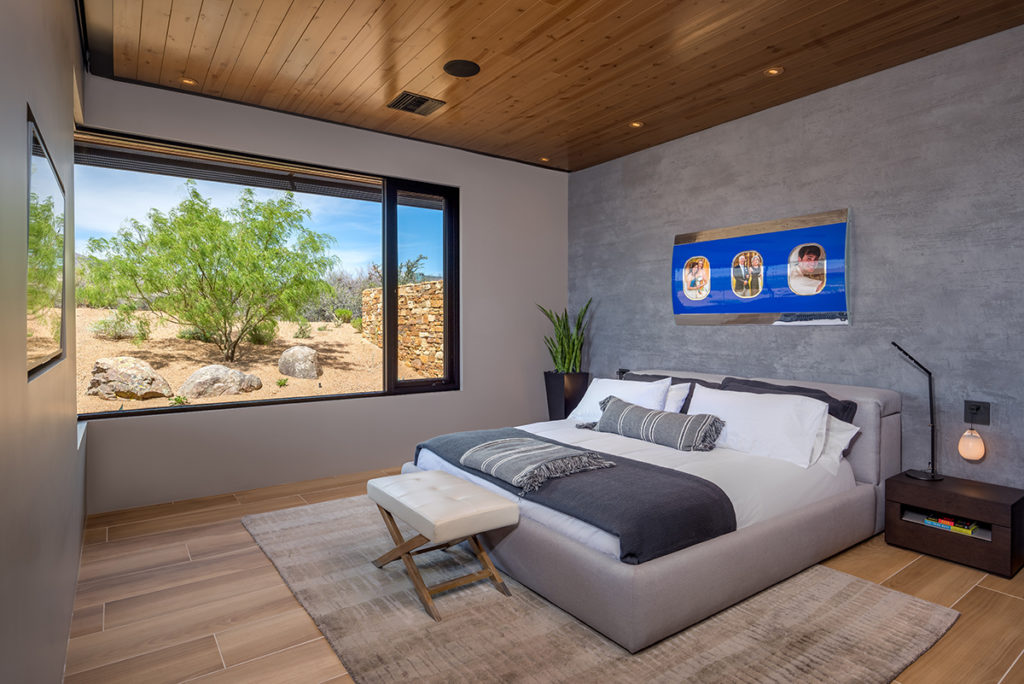 A 90-degree window and casement window invite desert views into this bedroom.