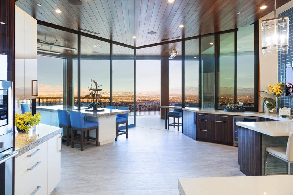 The kitchen opens wide to the outside via 90-degree sliding glass doors.
