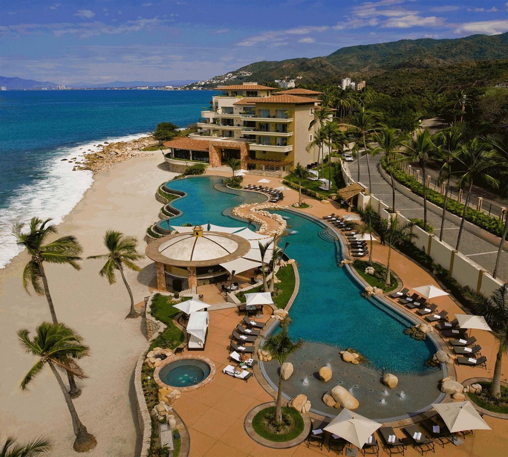 A top down view of the resort with two pools and an ocean front.