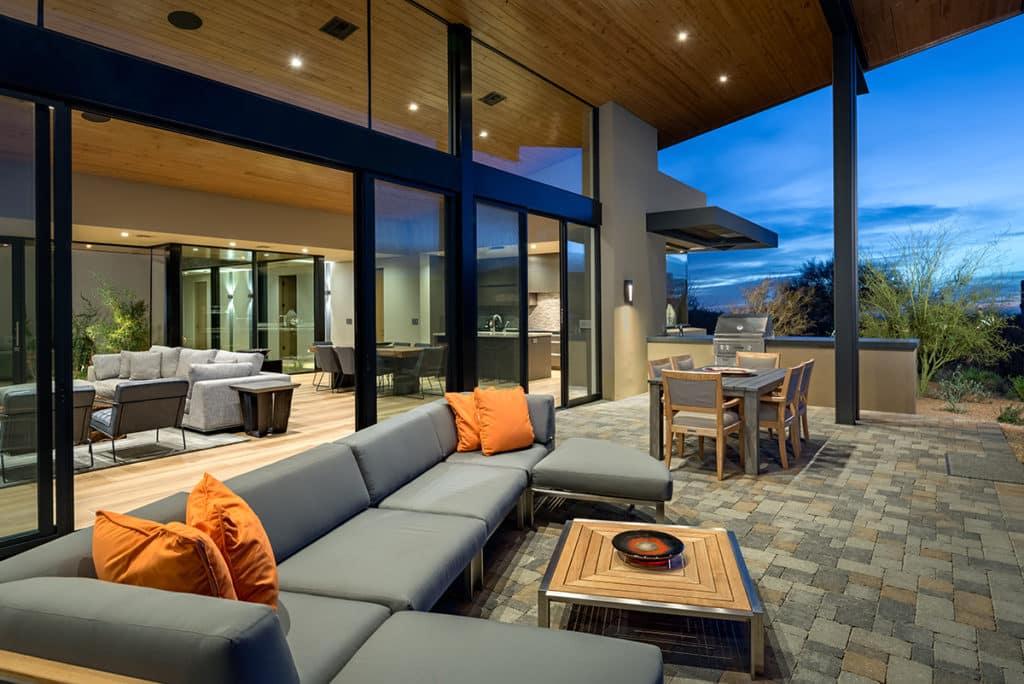 Large sliding glass doors and clerestory windows connect the home’s interior to the outdoor entertainment area.