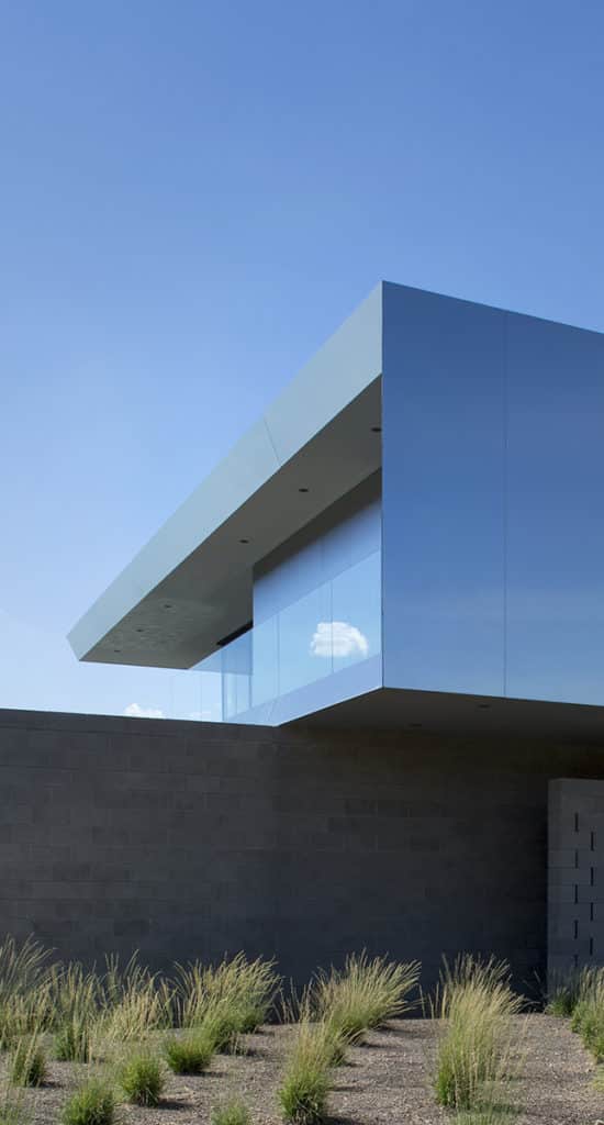 Modern design in the Arizona desert is showcased by the reflective windows and concrete base.