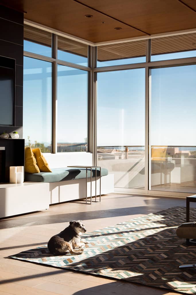 A massive sliding glass door maintains energy efficiency in this lounge area filled with desert sunlight.