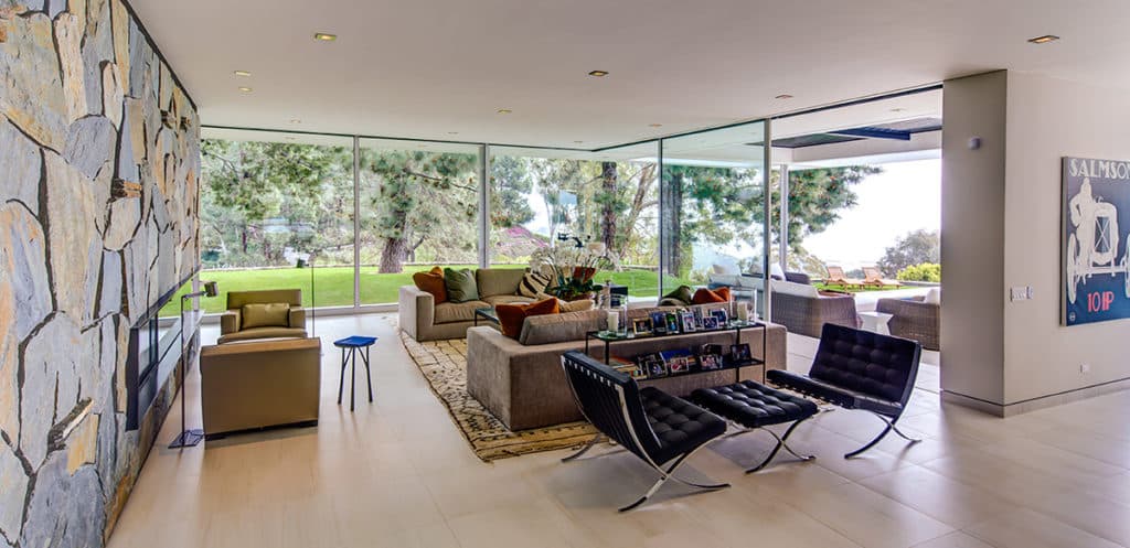 The mid-century stylings of the home complement the contemporary, elegant profile of the huge panels of glass that frame the landscape.