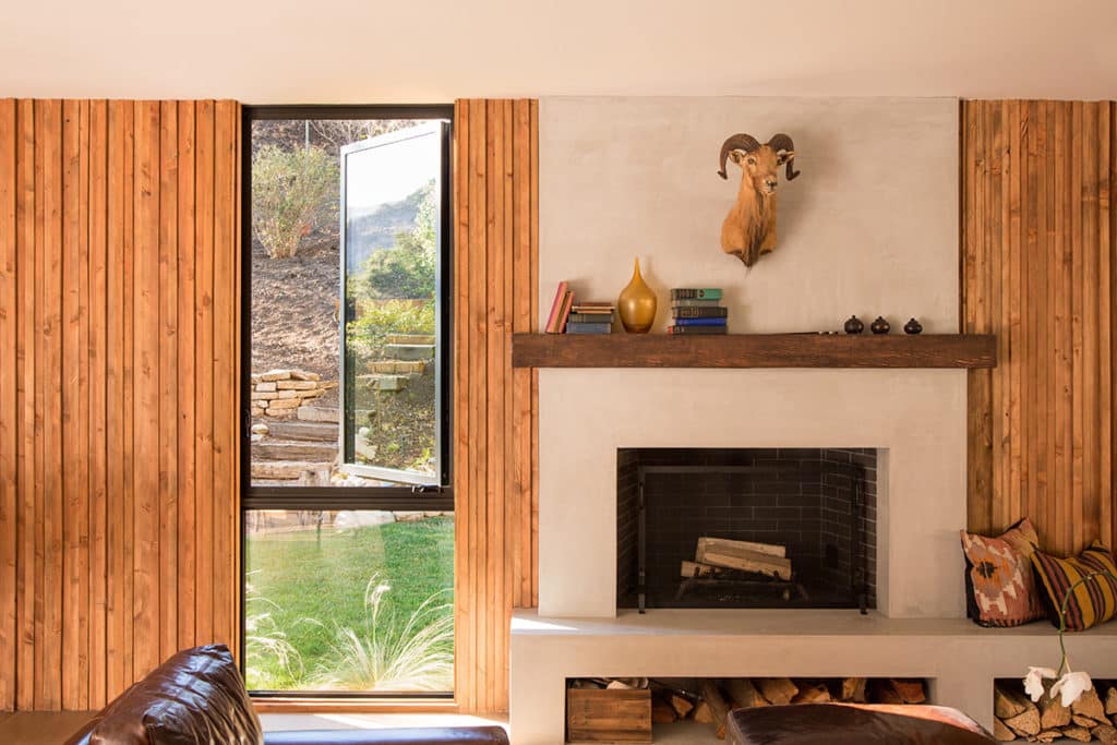 A hinged window complements a fixed window next to this room’s fireplace.
