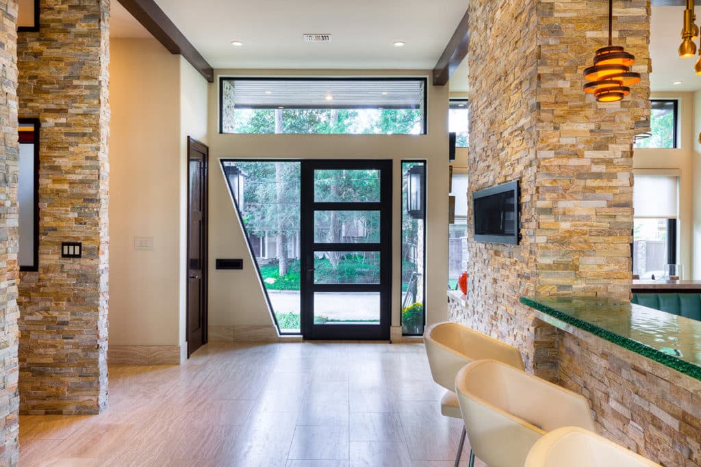 Western Window Systems offers all shapes and sizes of custom windows, showcased by a custom, quadrilateral window next to a divided lights front door.