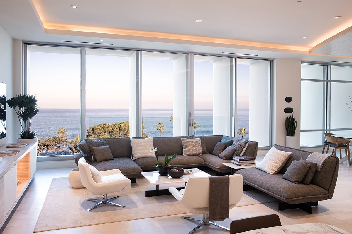 A massive multi-slide door frames views of the oceanfront in this seating area.