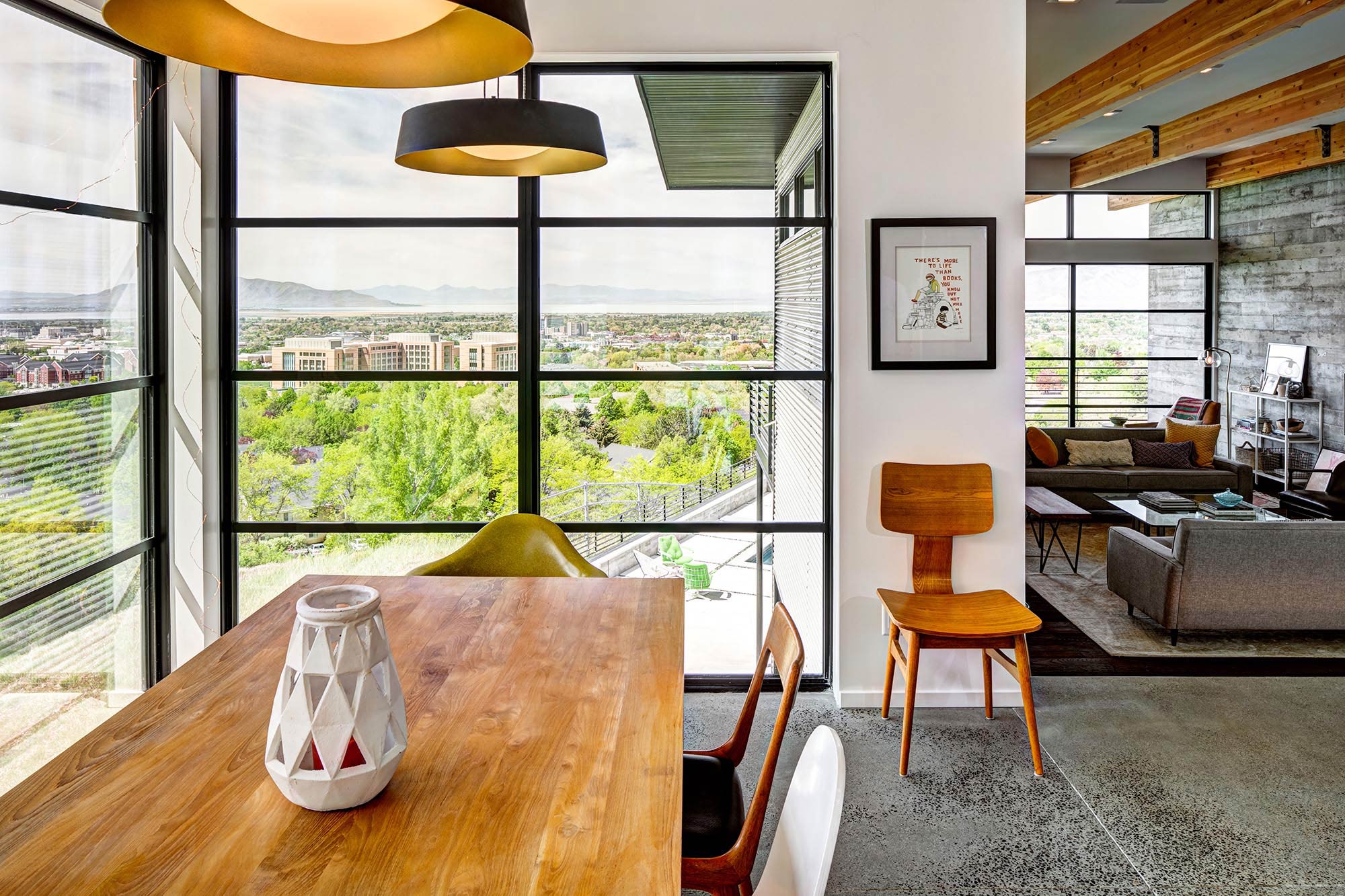 The window wall in this dining area provides beautiful views of the neighborhood with trees.