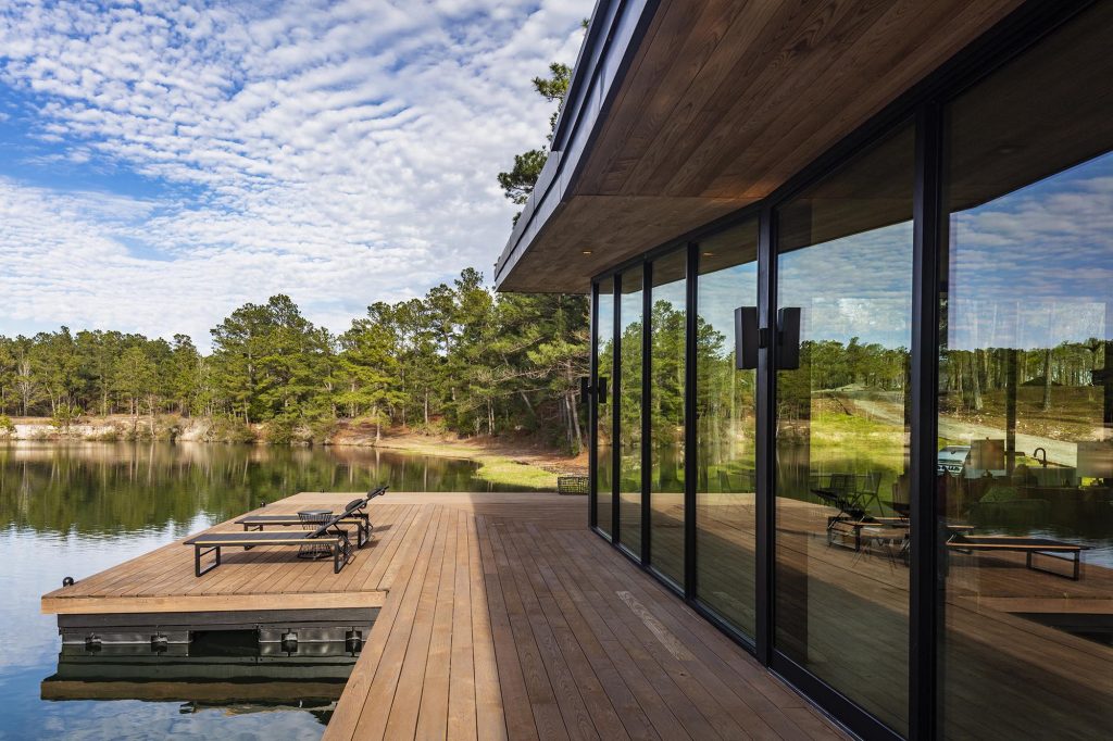 Floor-to-ceiling sliding doors completely open this home to the patio and lake the house sits on.