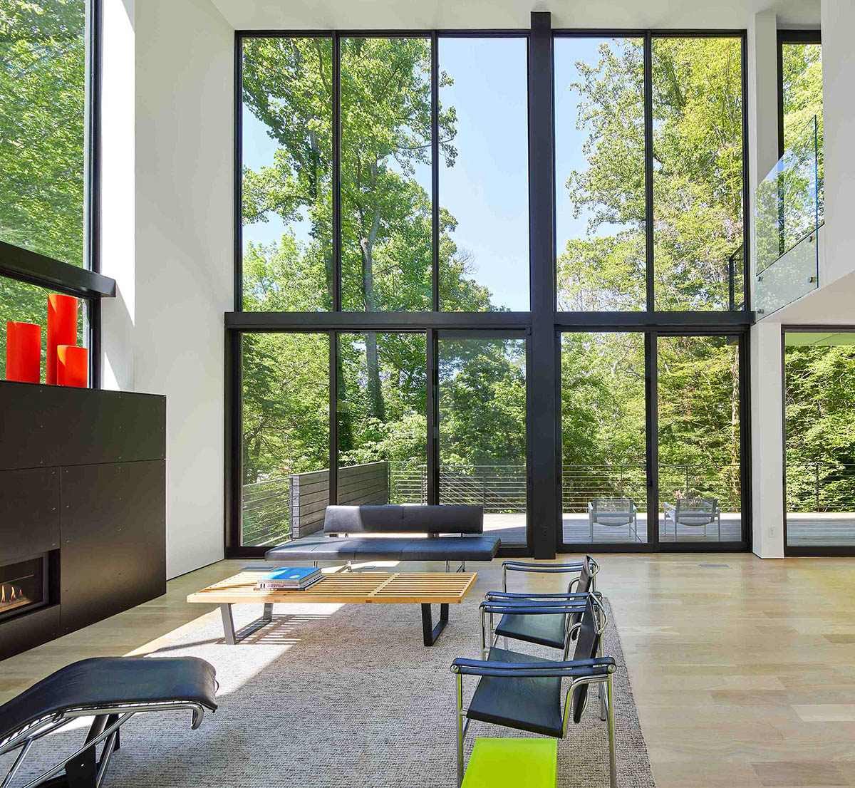 Floor-to-ceiling glass captures the grand views of nature behind the home, creating a serene indoor environment.