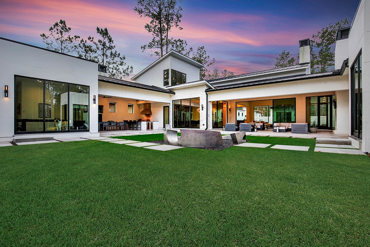 This golf course home embraces indoor-outdoor living through large multi-slide doors around the house.