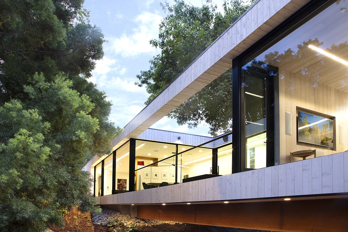 The courtyard-like balcony is made up of moving glass walls that look out to the nearby trees.