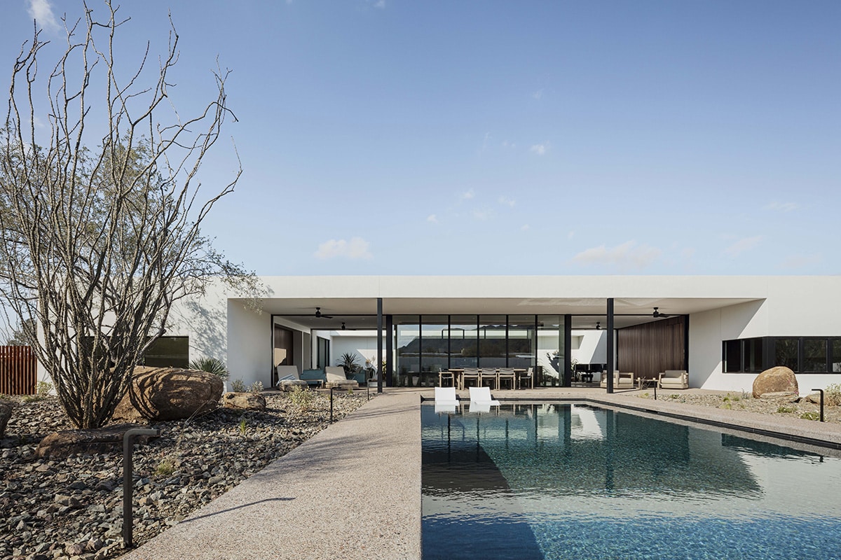 The pool projects out from the O-shaped designed home, an elongated oasis oriented toward the desert mountain views to the south.