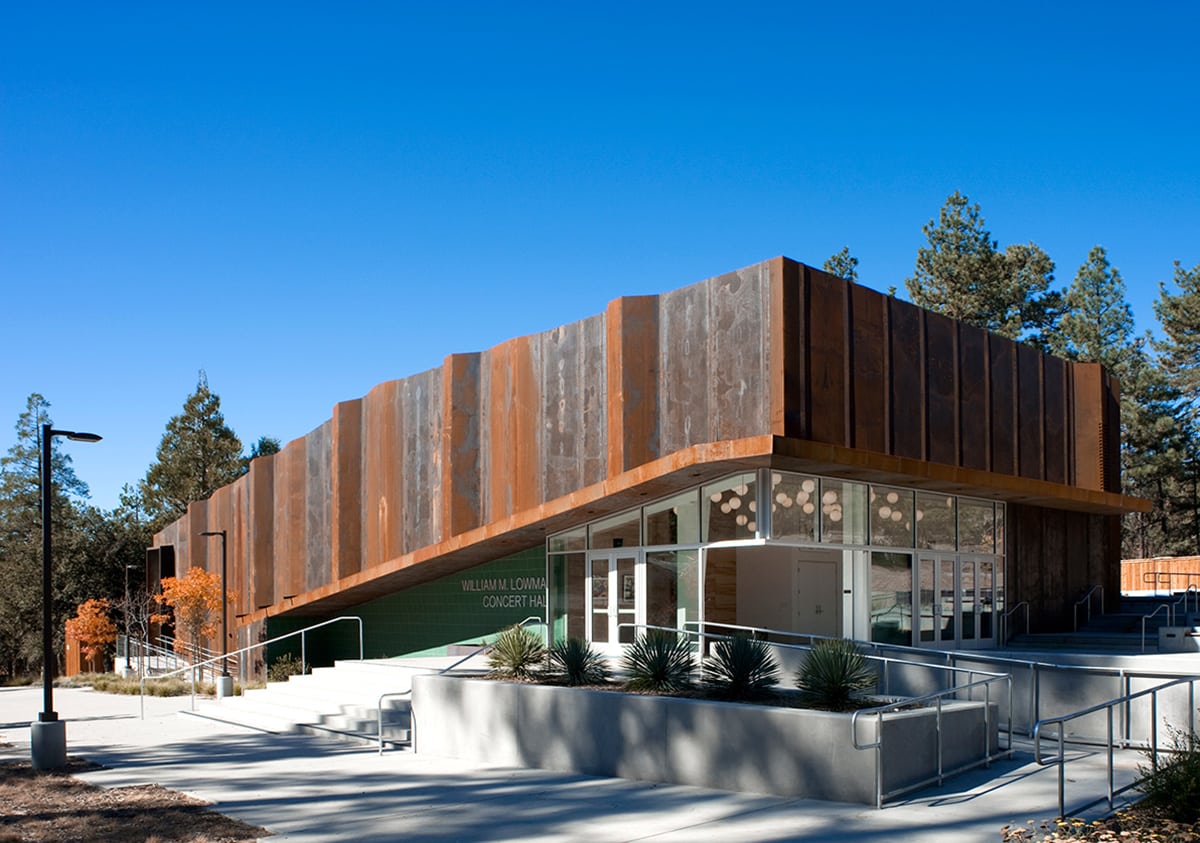 The rustic building is elevated by a corner of fixed windows and a 90-degree multi-slide door.