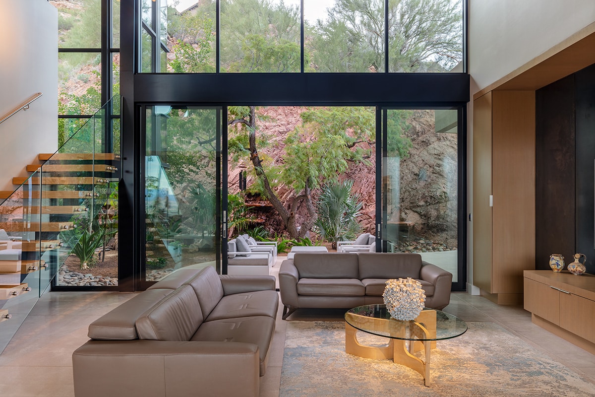 The sitting room features a 21-foot-wide multi-slide door opening to an outdoor seating area next to the red rock.