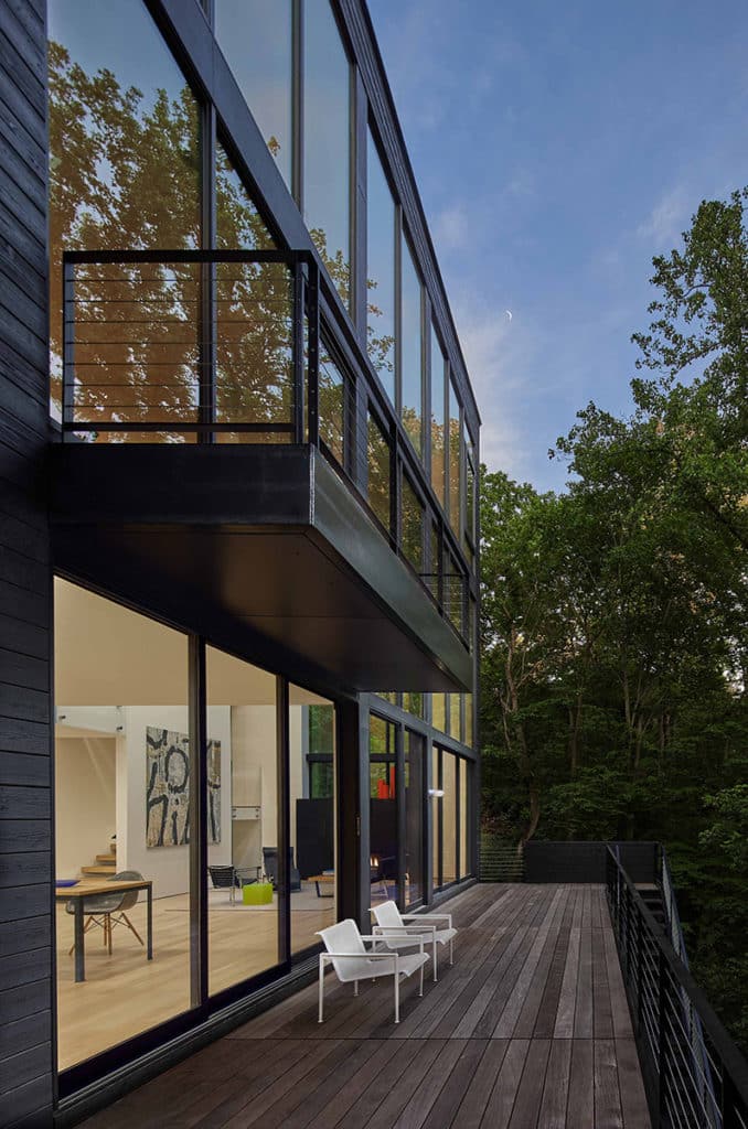 Balconies on each level of the home connect the indoors to the outdoors through wall length glazing and glass doors.