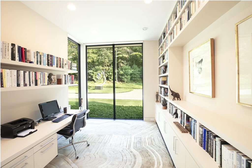 The floor-to-ceiling fixed window walls allow for natural light to flood this in-home office space.