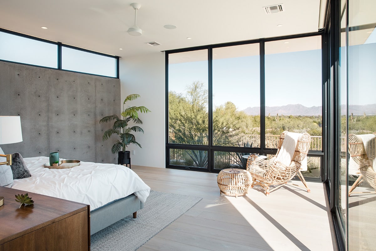 Big glass, like the window wall framing desert views in this bedroom, played a role in the design of the home from the outset.