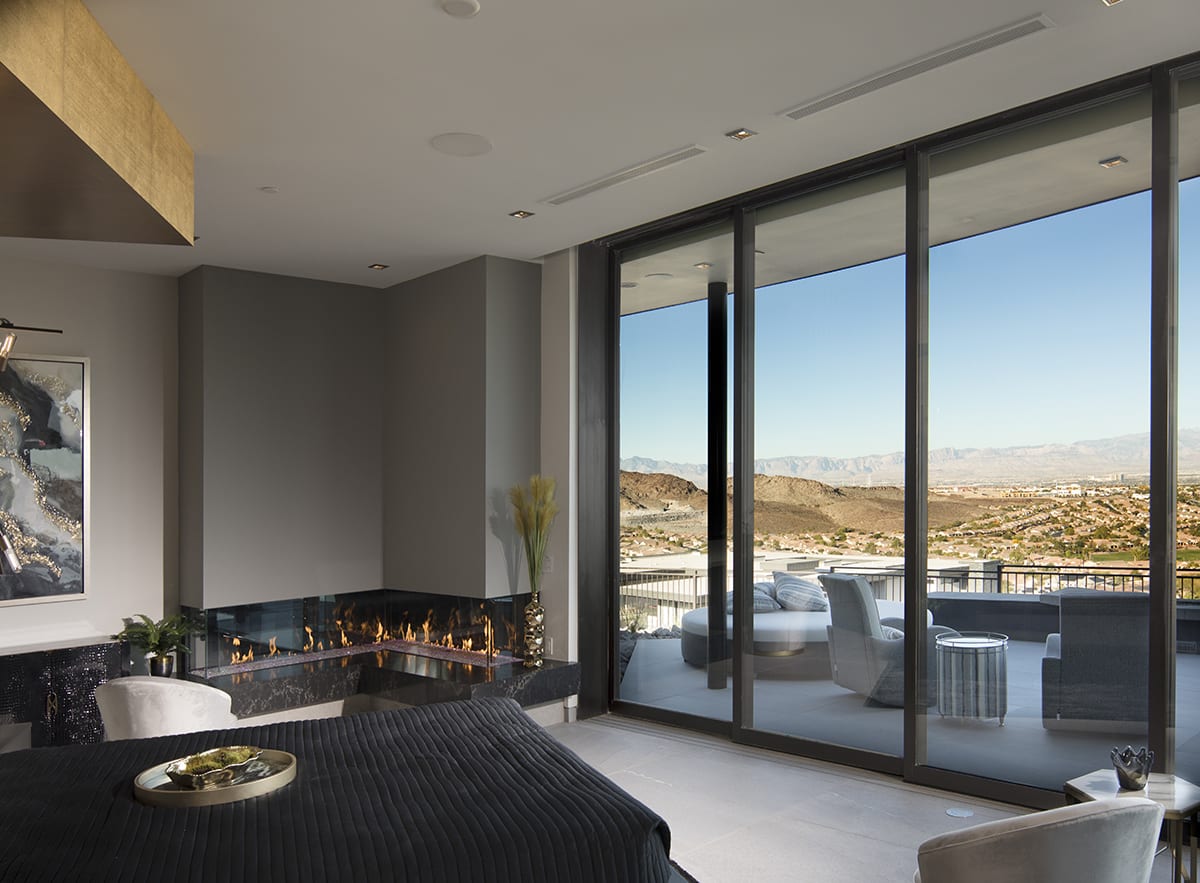 A massive, wall-to-ceiling multi-slide door connects this master suite to an outdoor seating on the balcony.