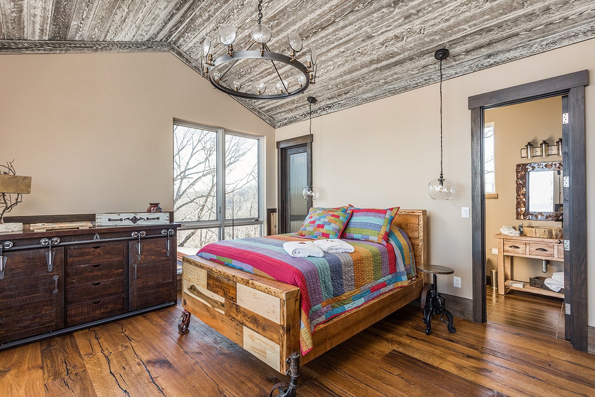 This rustic guest bedroom is bathed in natural light thanks to a pair of casement windows from Western Window Systems.