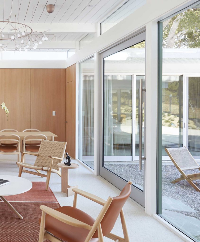 A pivot door connects the indoor seating area to the outdoors.