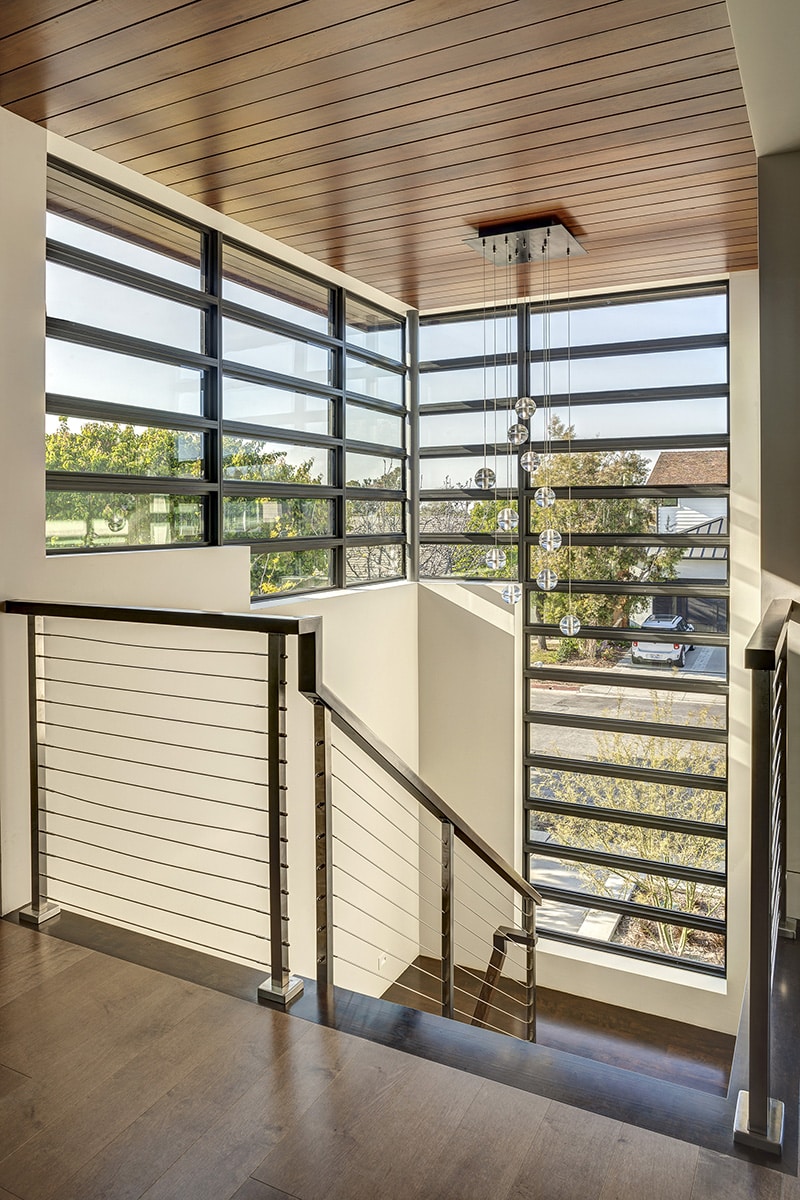 An eye-catching stack of small, rectangular Western Window Systems fixed windows surrounds the front stairwell.