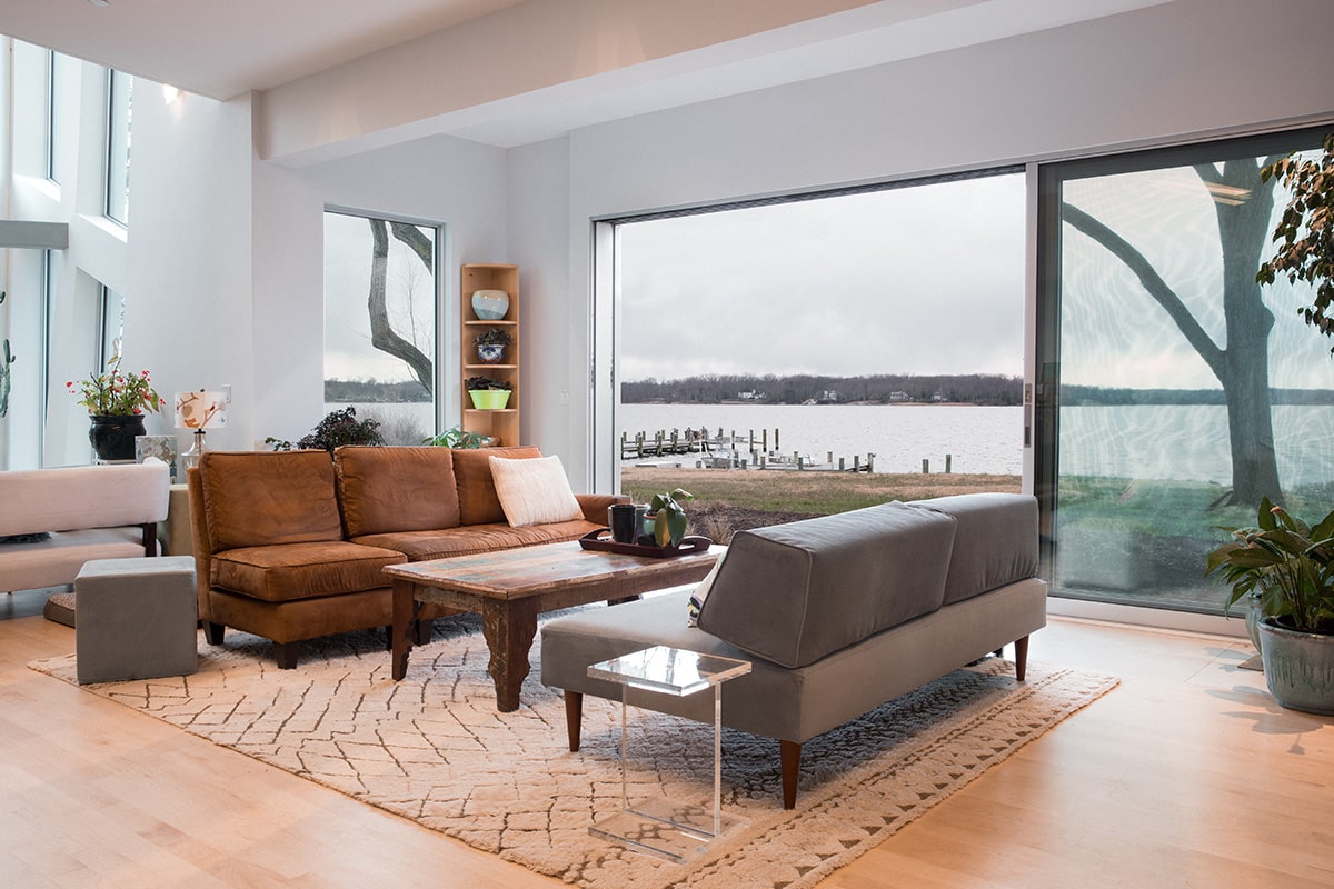 Western Window Systems’ Series 600 Multi-Slide Doors open the living room to the riverside backyard area.