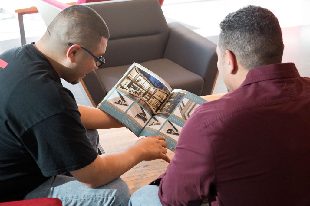 Two employees looking at a brochure.