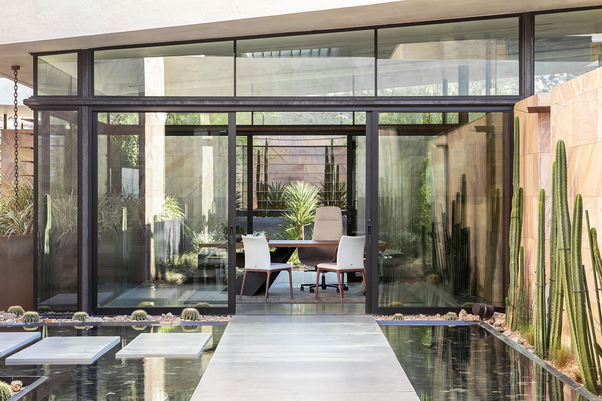The home office encased in glass with an open sliding door leading to the walkway.