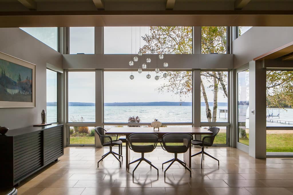 A massive window wall frames lake views in this modern dining room.
