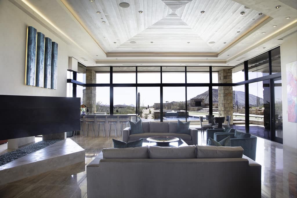 Floor-to-ceiling glass provides panoramic views of the Desert Mountain landscape.