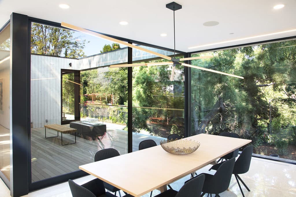 The outdoor terrace is framed by three multi-slide doors.