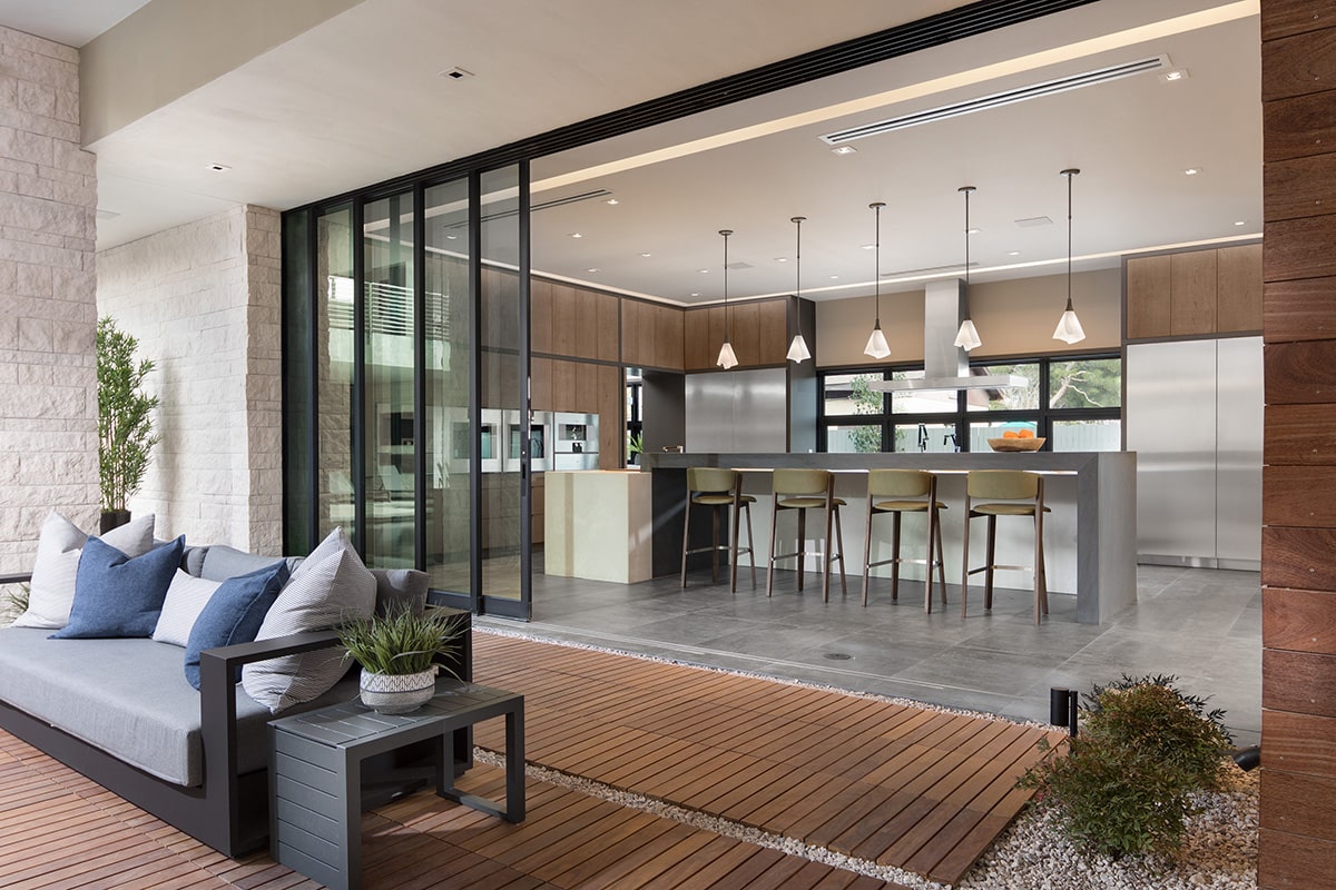 Multi-slide doors blur the transition between the inside kitchen and the outside seating area.