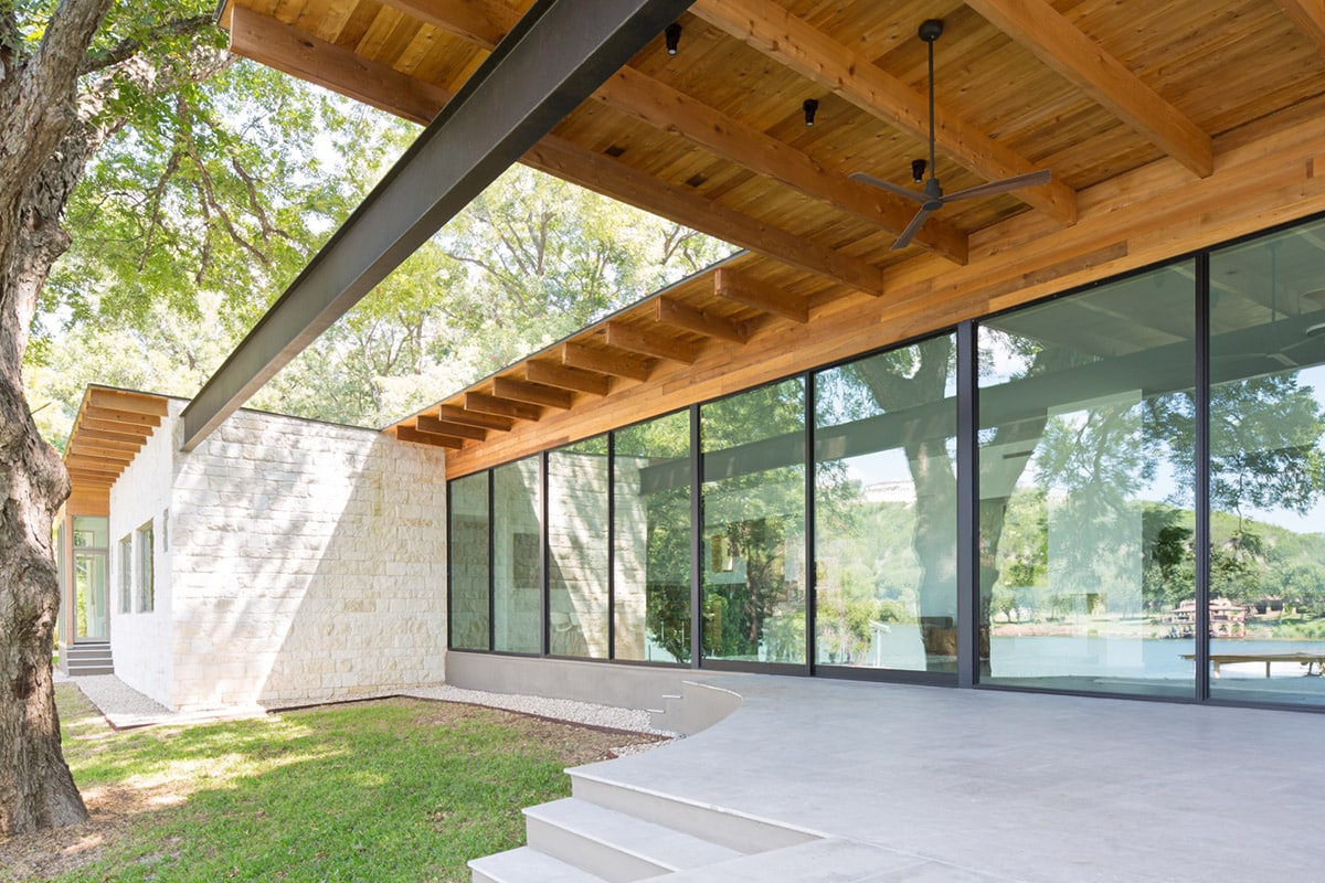 The architect did away with supporting columns and replaced them with a 64-foot clear-span steel beam that partially sits above a wood covered terrace in front of the glass wall.
