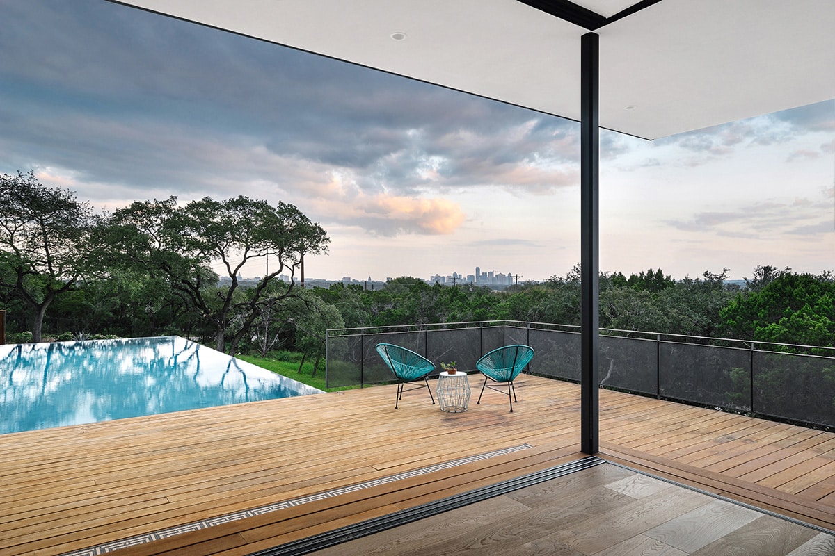 The Austin skyline is visible from virtually anywhere in the house, particularly where two multi-slide glass doors meet at a corner near the pool.
