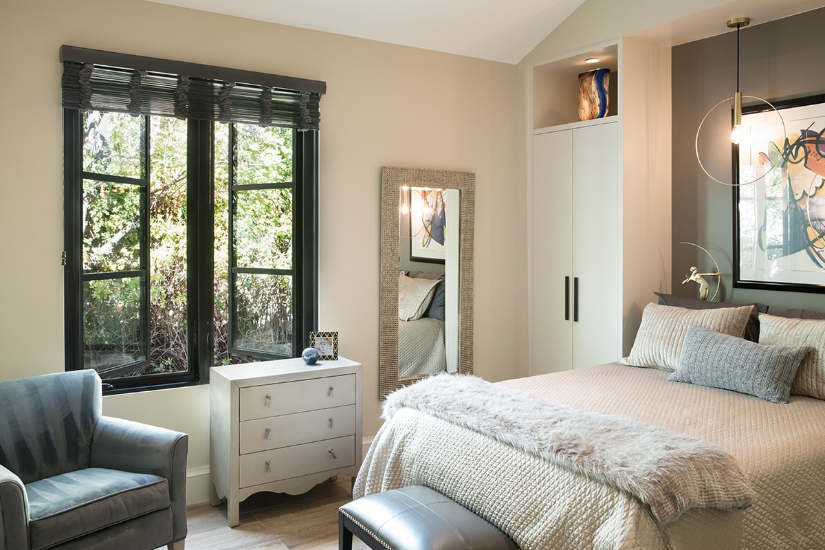 Energy-efficient windows let in tons of light and provide a modern aesthetic in a cozy bedroom.