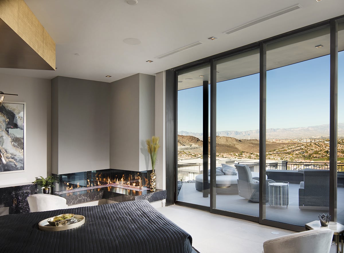 The master suite features large sliding glass doors that open onto a private patio with views of the Las Vegas Valley.