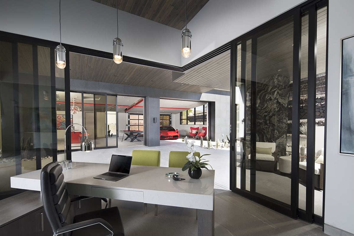 A 90-degree, four-panel multi-slide door opens this modern office to the massive outdoor living space that connects to the parking garage with other amenities.