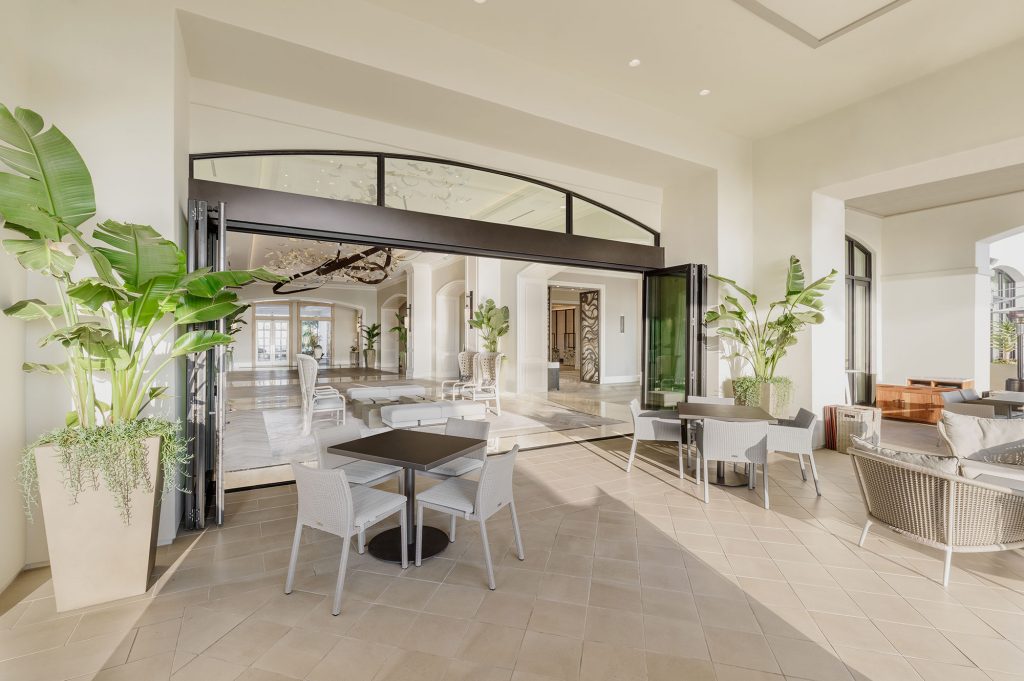Bi-parting, bi-fold doors connect and outdoor seating area to an indoor seating area.