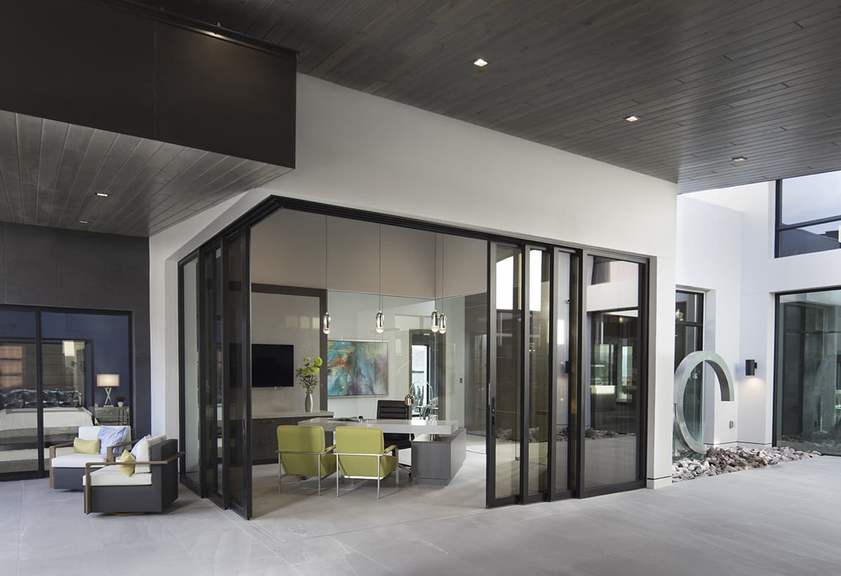Darker colors on the doors’ and windows’ aluminum frames, like the dark-framed glass doors for the office, help the home blend into the mountainside.