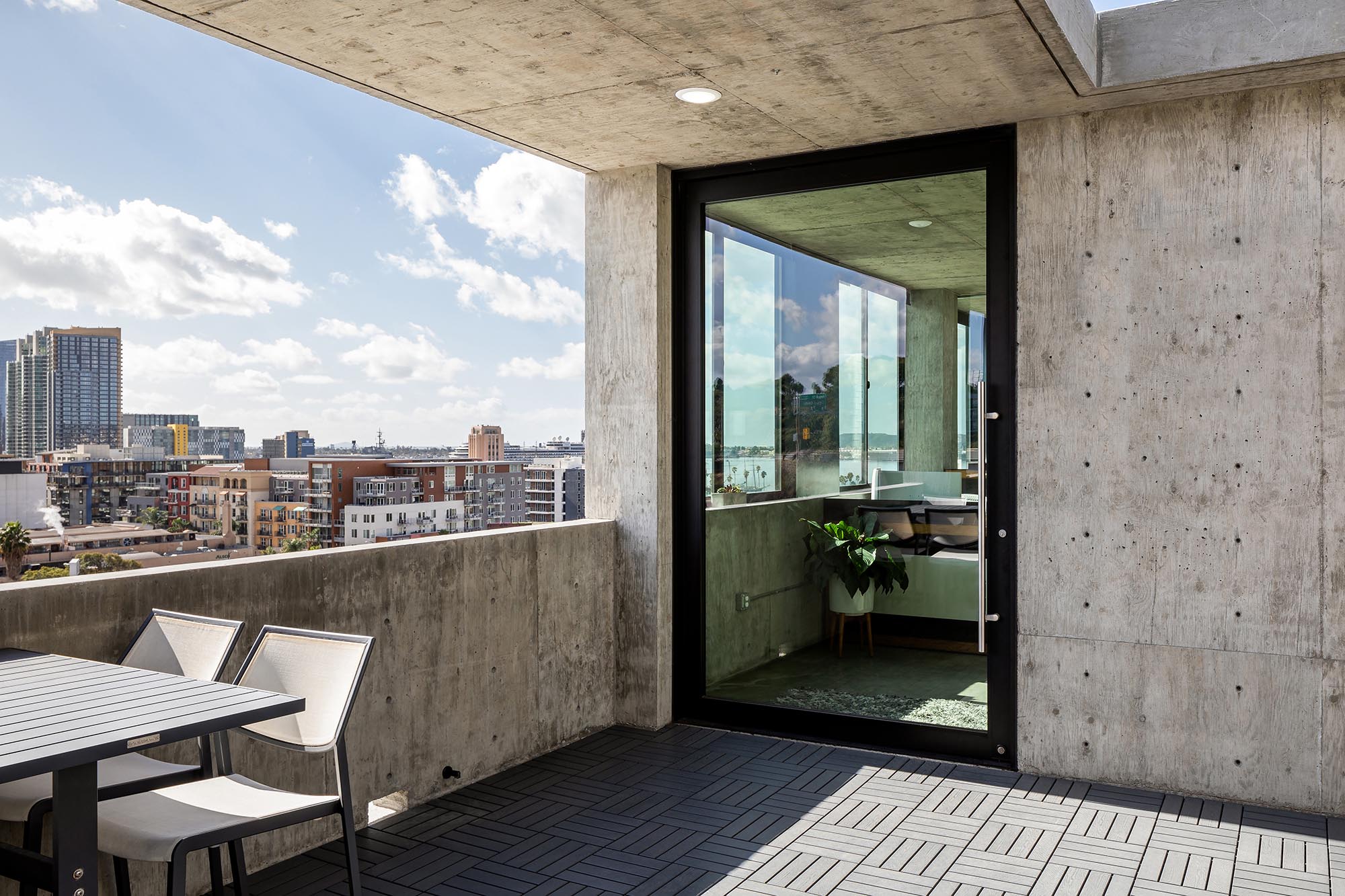 A covered balcony connects to this home’s interior through a large pivot door.