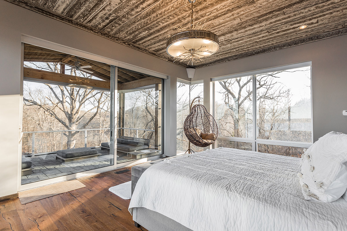 Huge panels of glass bring the outdoors in to this cozy bedroom.